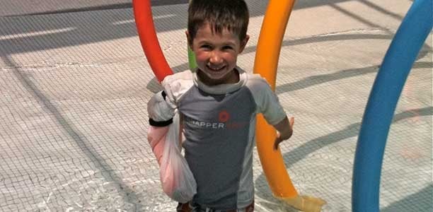 szczęśliwy chłopiec ze zlamaną ręką na placu zabaw