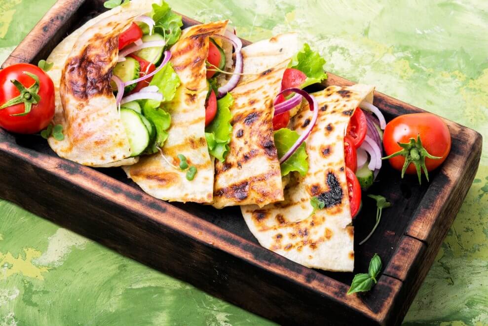Vegetarian pitas sit on a serving tray.