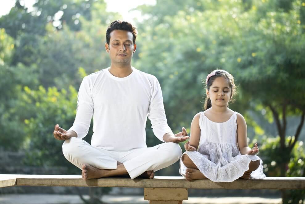 father-and-daughter-meditating-outdoors