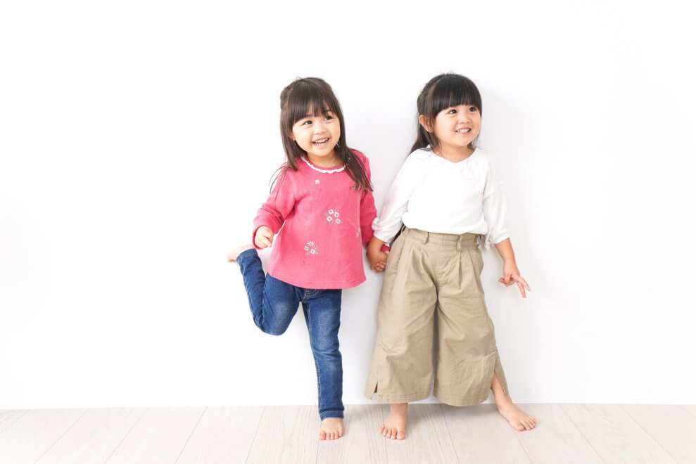 Two young friends hold hands.