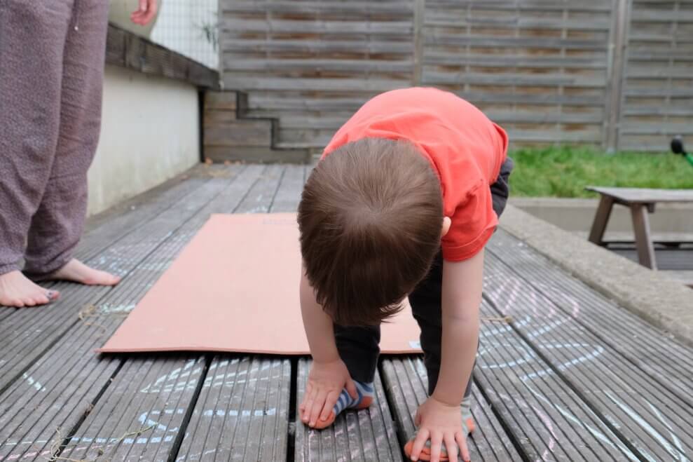 A toddler demonstrates forward fold.