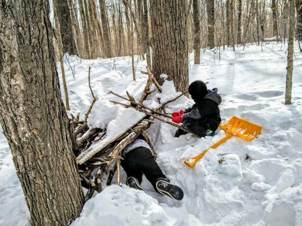 Brothers build a fort in the snow