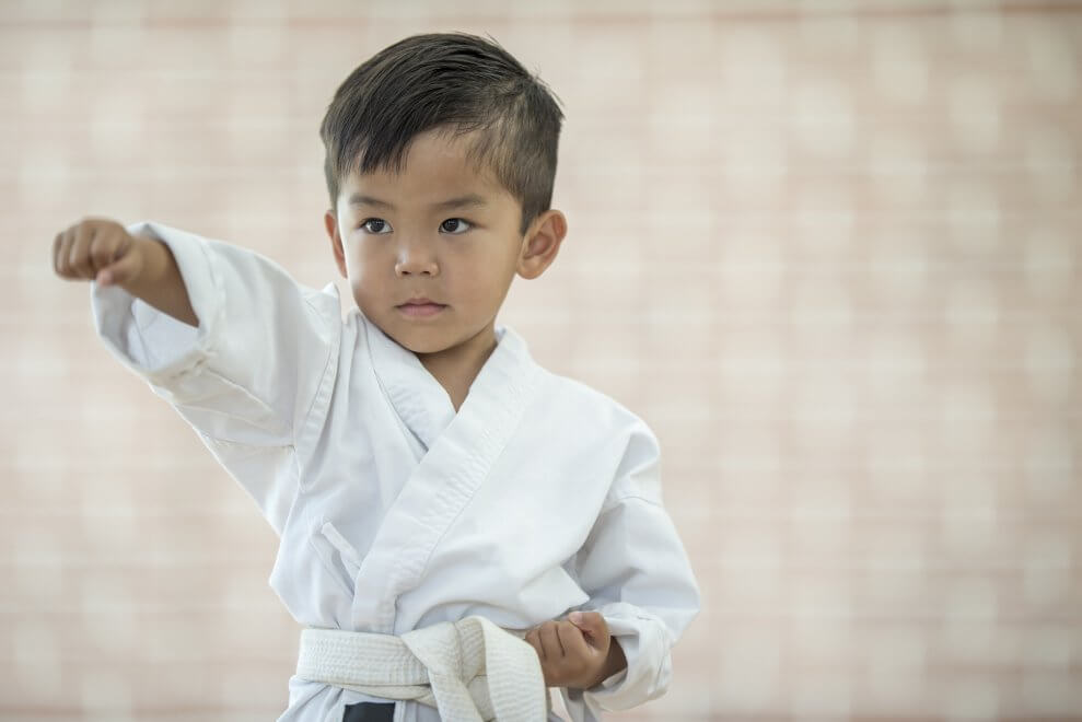 A boy does a karate move.