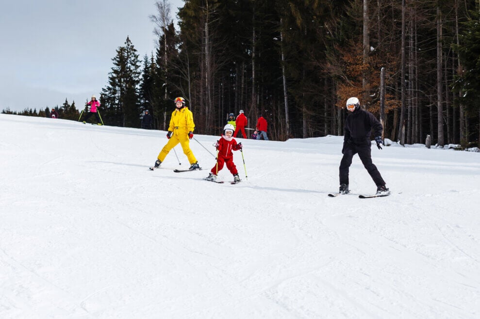 Two parents and their child skiing together at a ski resort