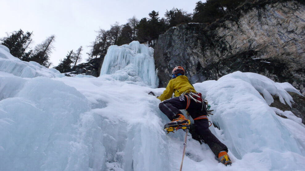 Person climbing up a frozen waterfall