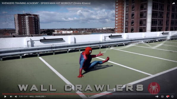 Glenn Higgins dressed as Spider-Man, performing wall crawlers in one of his exercise videos