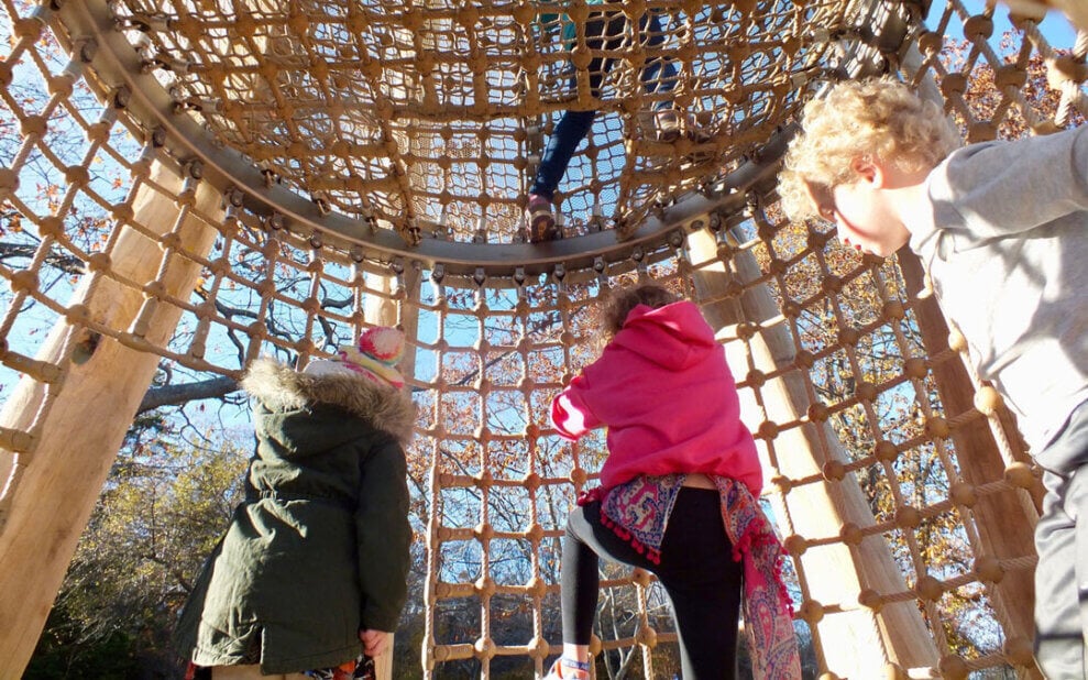 Kids climb on a rope tower at Dingle Playground in Nova Scotia