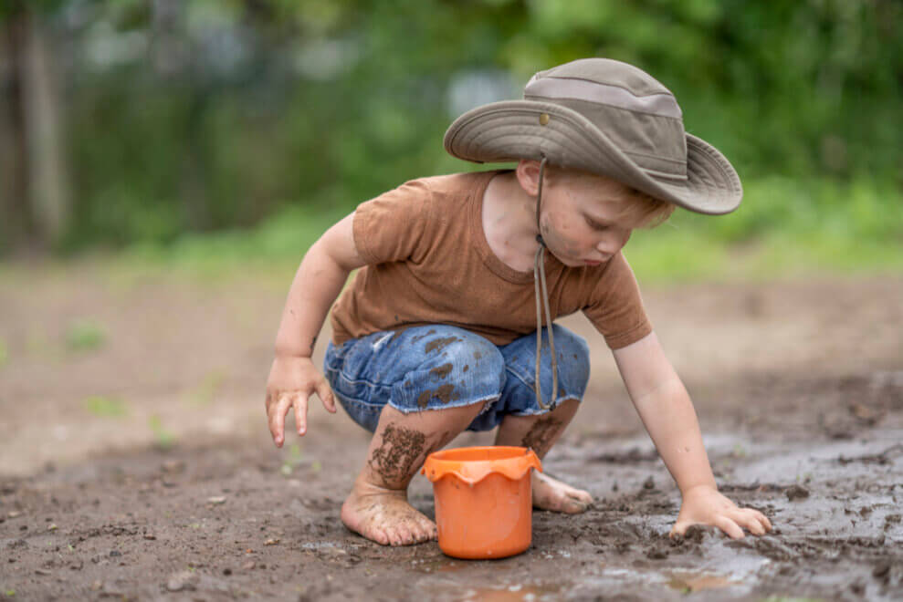 Boy playing in the mud, barefoot