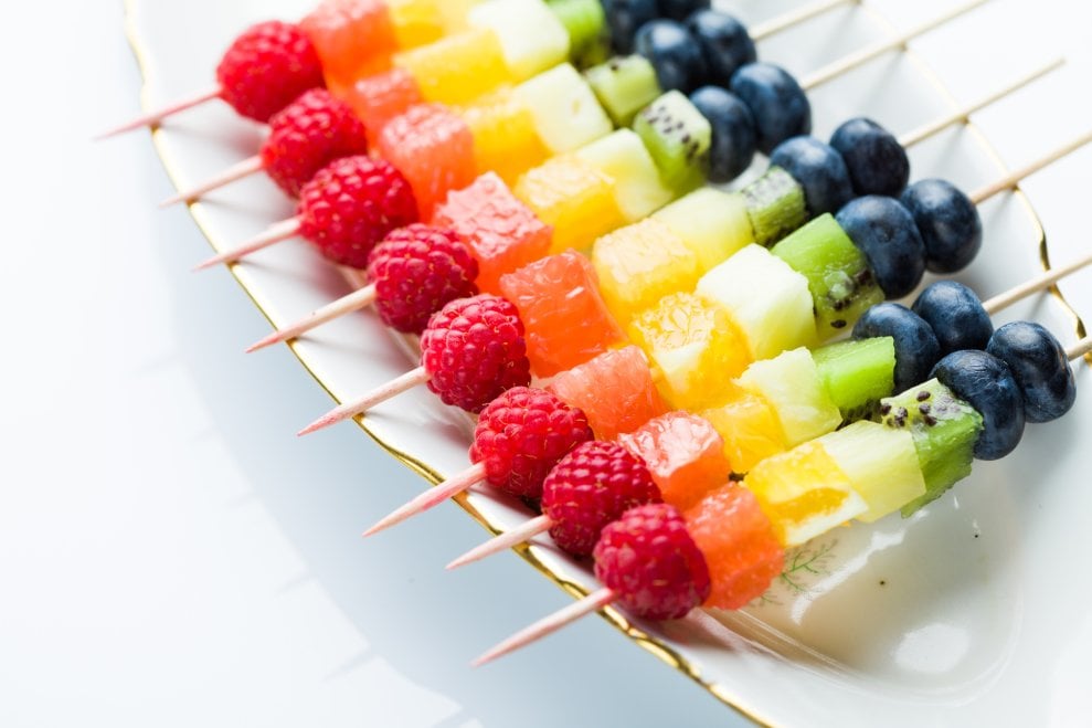 Rainbow fruit kebobs on a platter