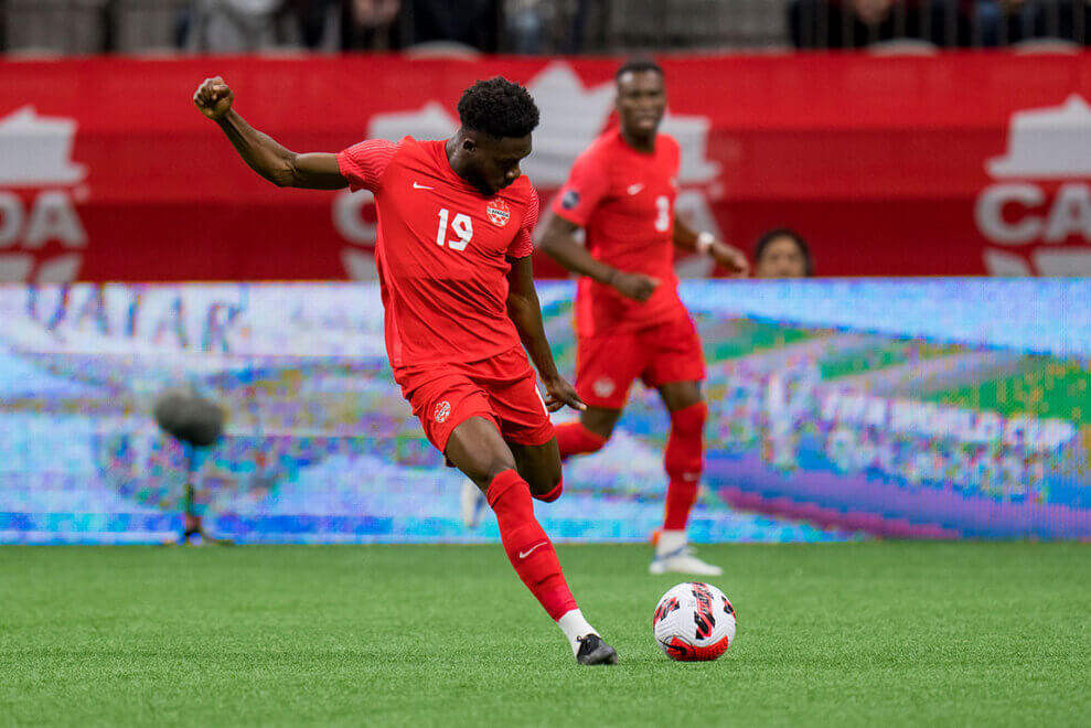 Alphonso Davies kicks the ball during a soccer game