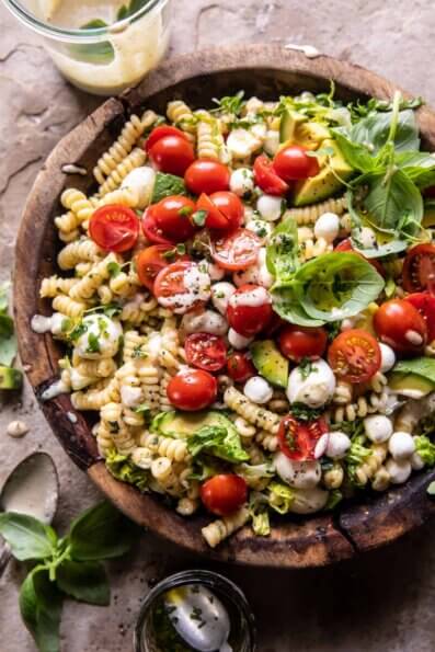 A Caprese Caesar salad contains cherry tomatoes, basil, and avocado.