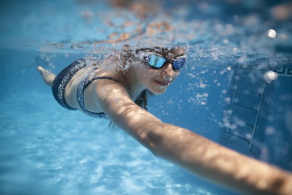 A girl does front crawl in a pool.