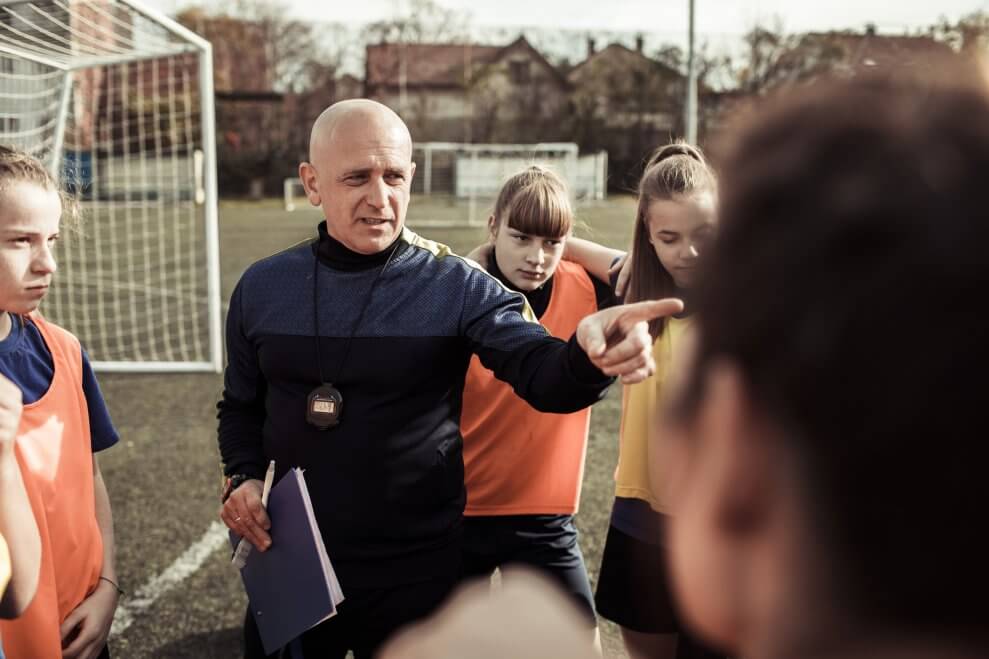 A coach lectures his players during a team huddle. 