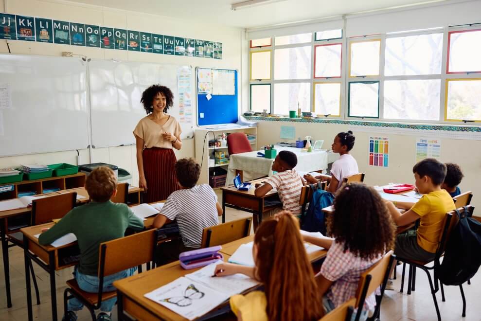 A teacher stands in front of her elementary classroom.