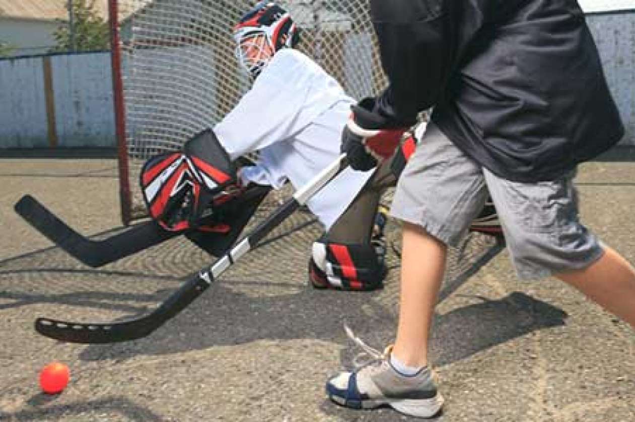 Two boys playing street hockey