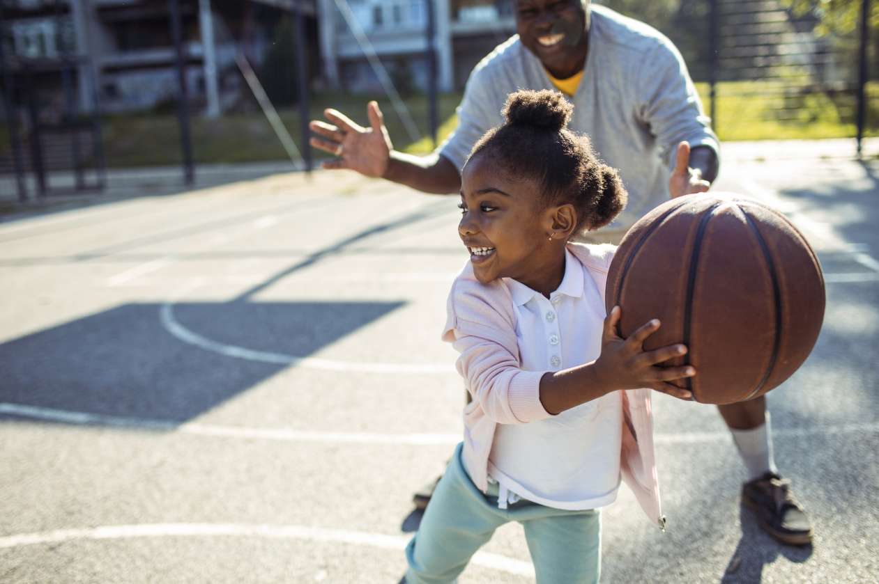 Girl learning to play basketball