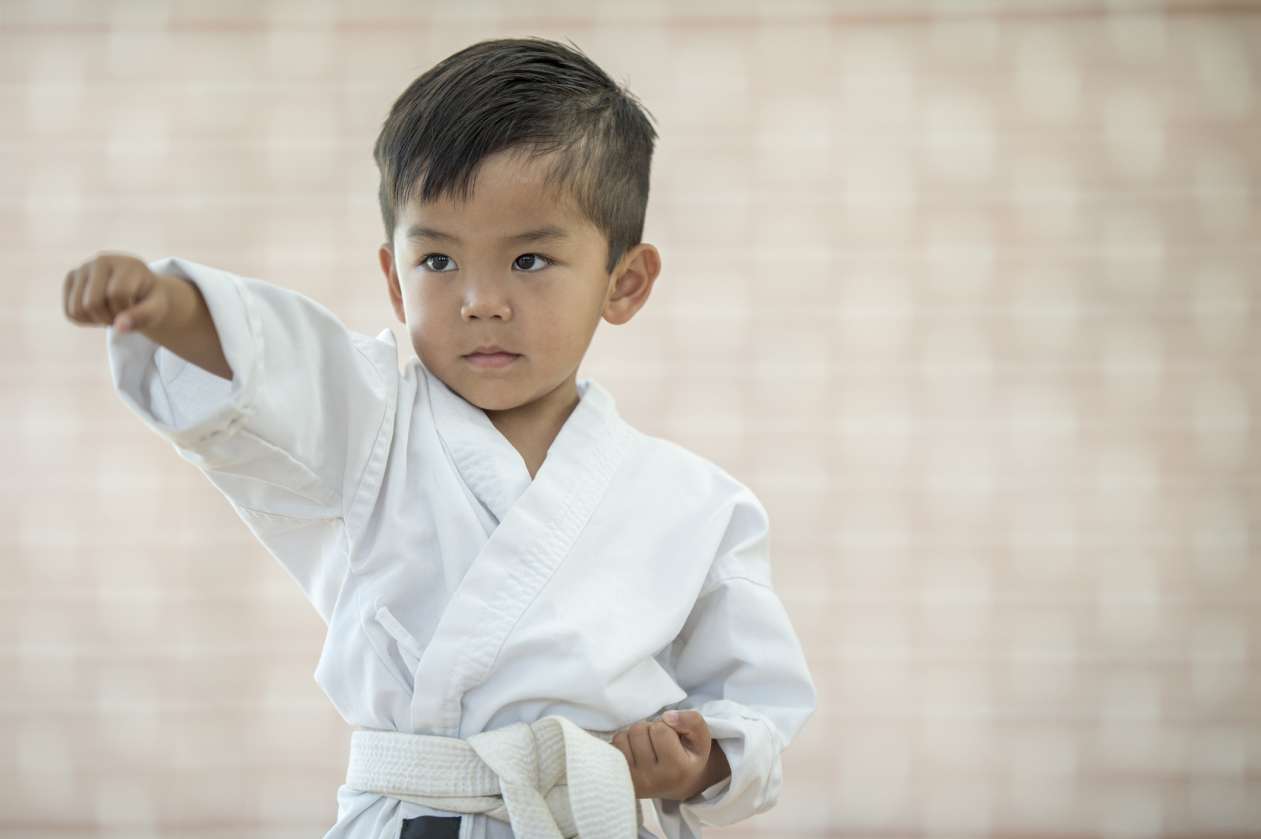 A boy does a karate move.