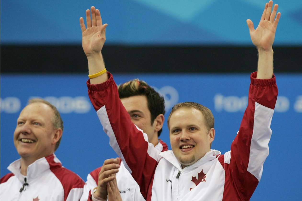 Olympic curler Mark Nichols holds his arms in air, celebrating