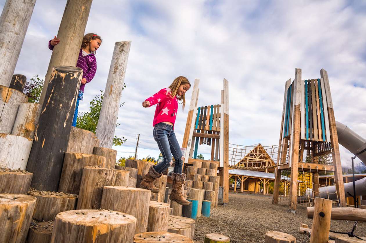 Two girls play on the log tops at Carcross' playground