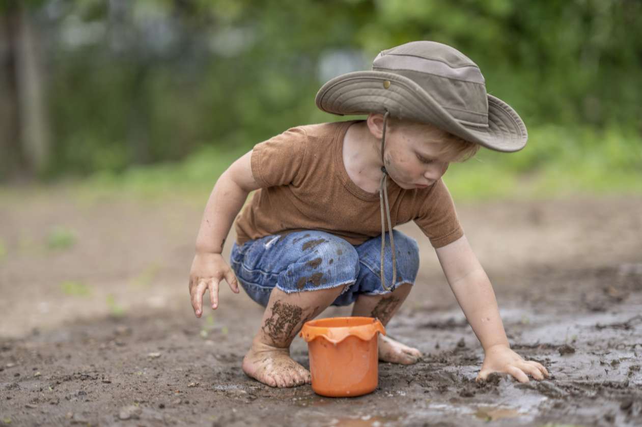 Boy playing in the mud, barefoot