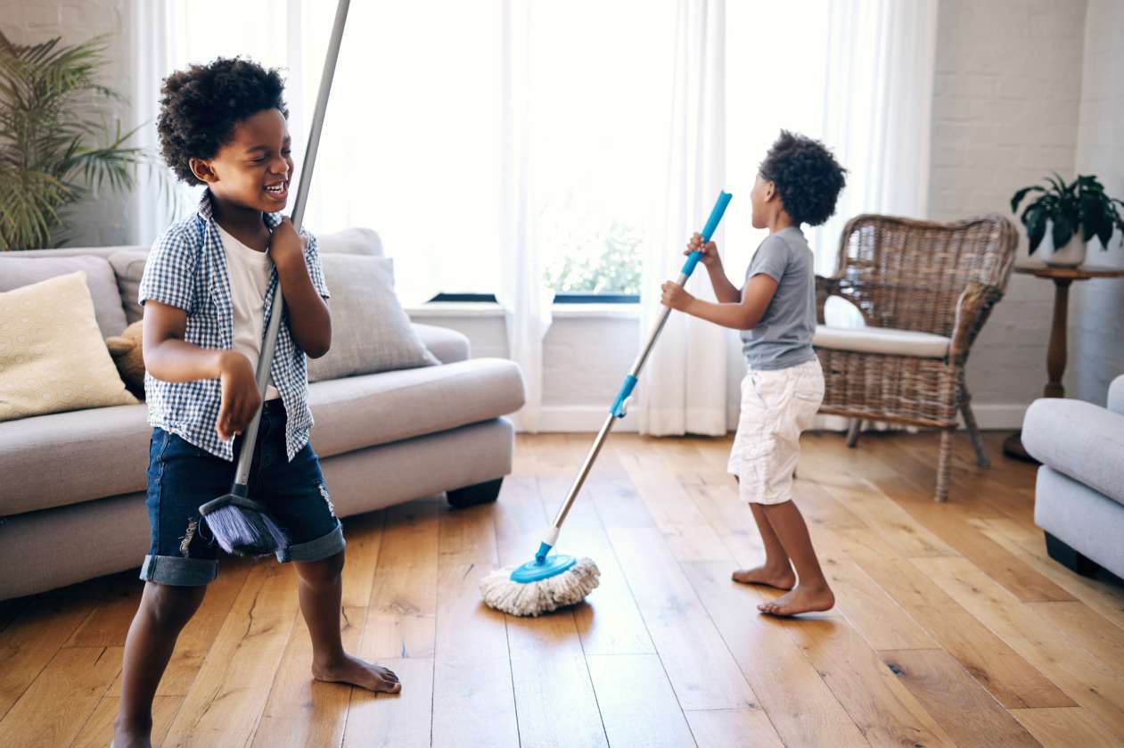 Two siblings mop the floor as they sing and dance