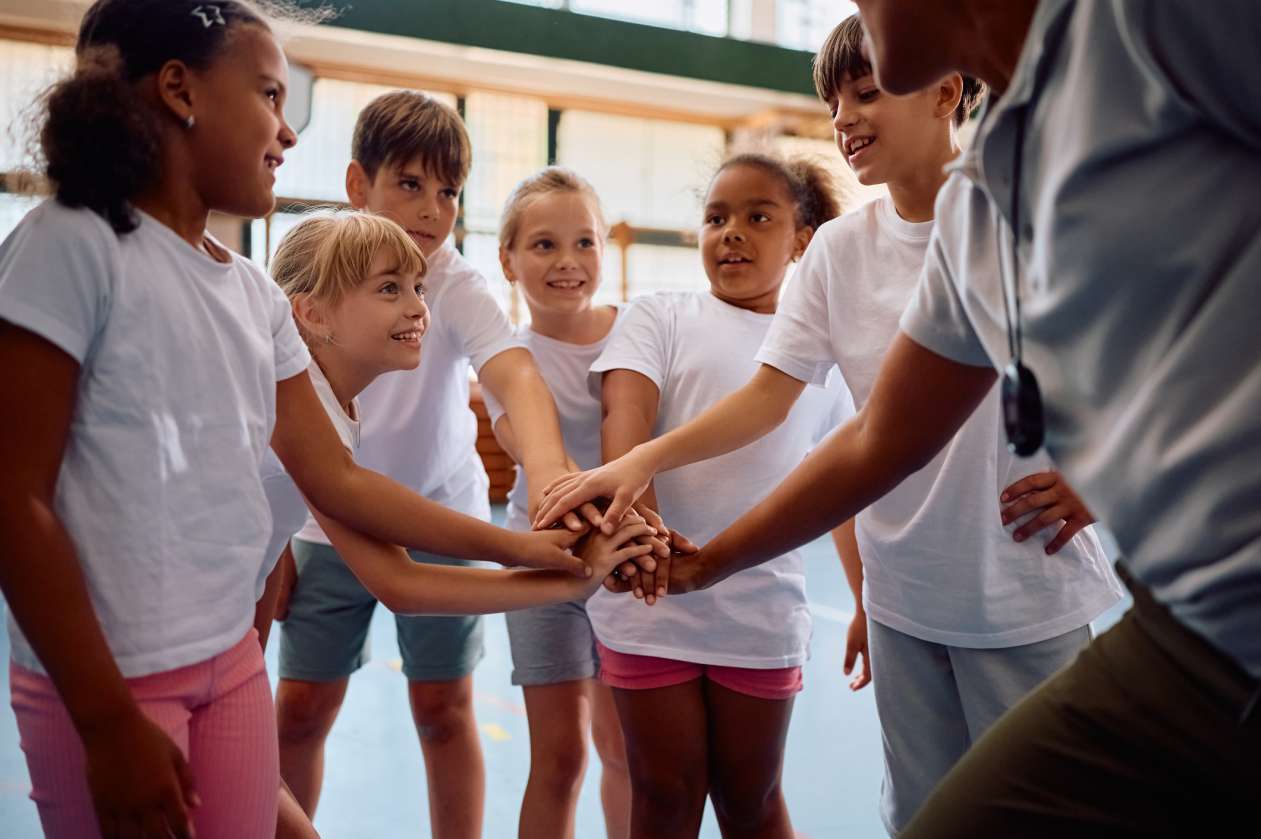 A group of kids does a team huddle during a rec sports game.