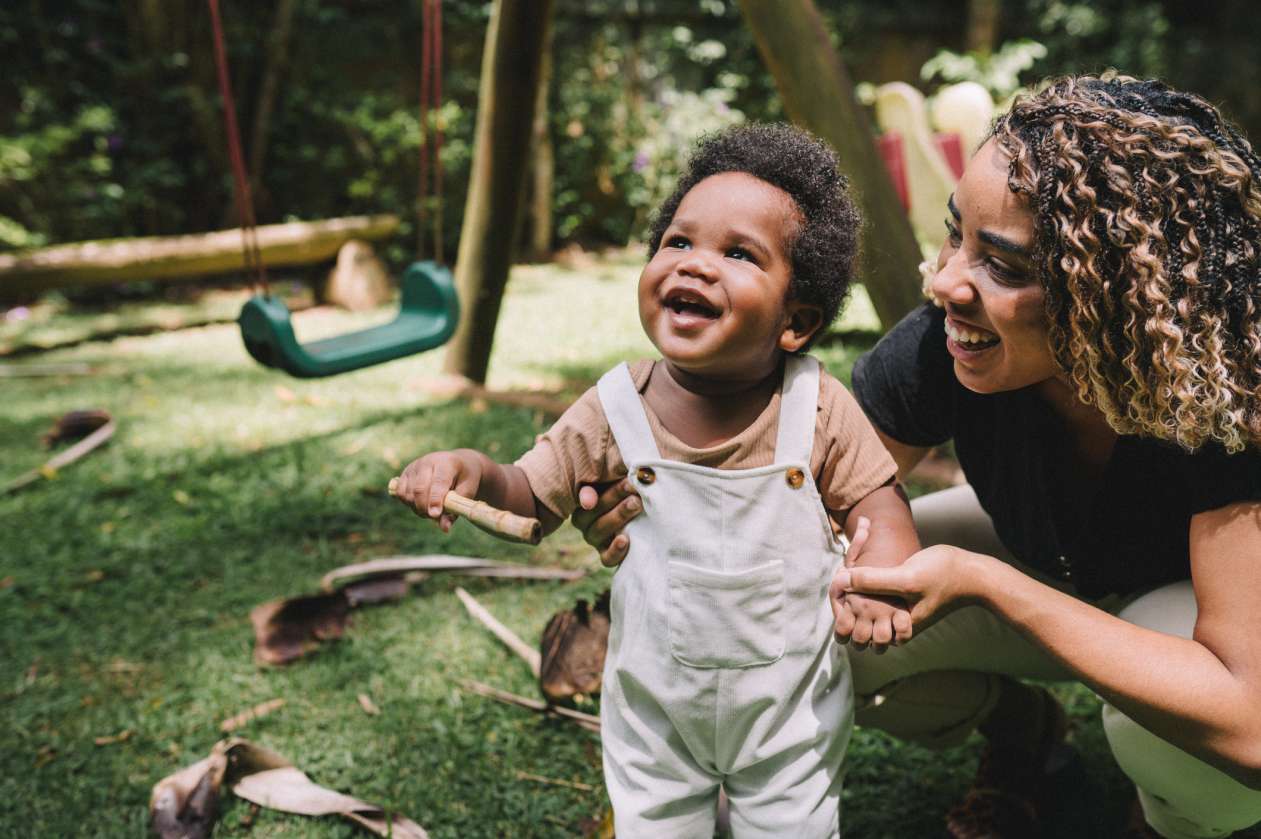 A mom and her toddler son play in the backyard together.